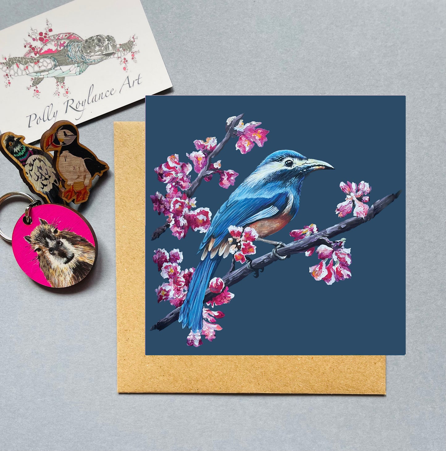 Card with a blue bird on a branch with pink blossom.