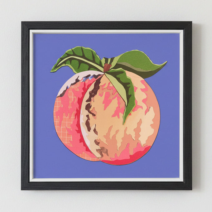 Framed artwork of a peach with green leaves on a purple background