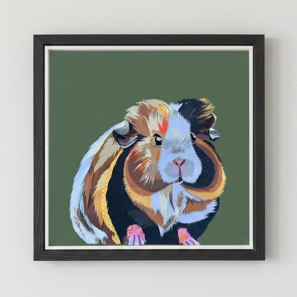 Framed artwork of a colourful guinea pig on a green background