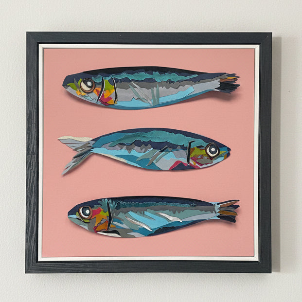 Framed artwork of three stylized sardines on a pink background