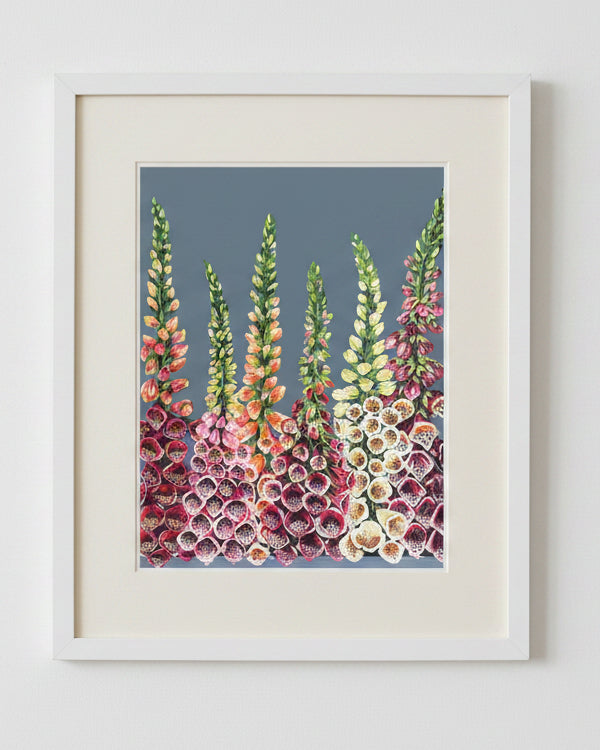 Acrylic floral artwork showing tall foxglove stems with pink, peach, yellow, and white blossoms against a muted blue-gray background.