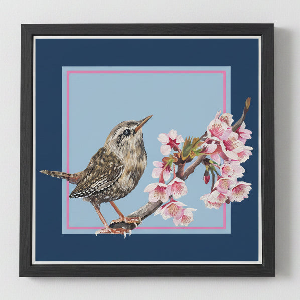 Framed artwork of a wren perched on a branch with blossom against a blue background.